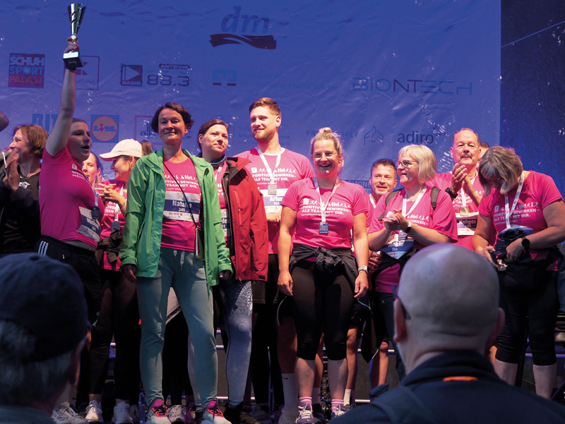 Mitarbeitende der Stiftung kreuznacher diakonie beim Firmenlauf 2025 auf der Bühne als Gewinner "Größtes Team"