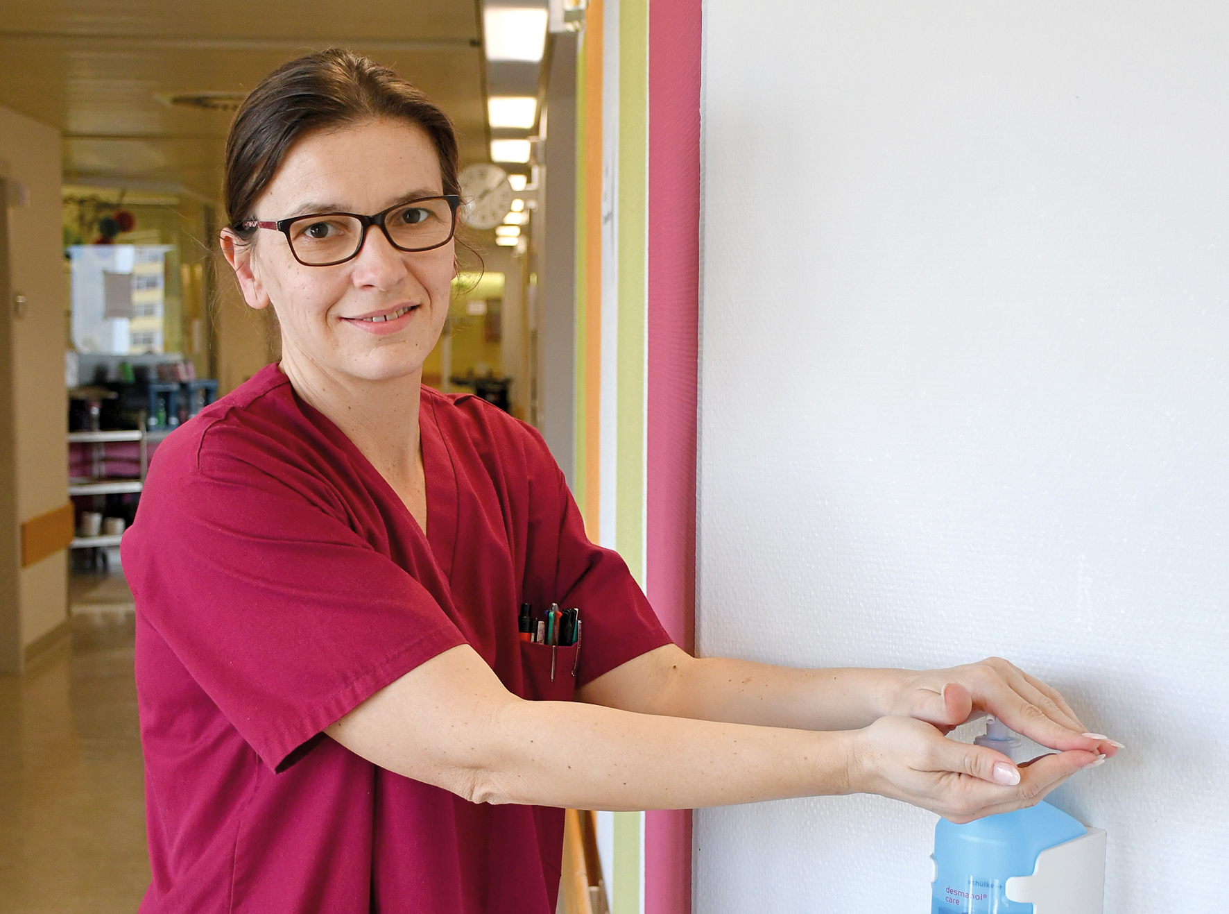 Frau desinfiziert sich im Krankenhaus die Hände