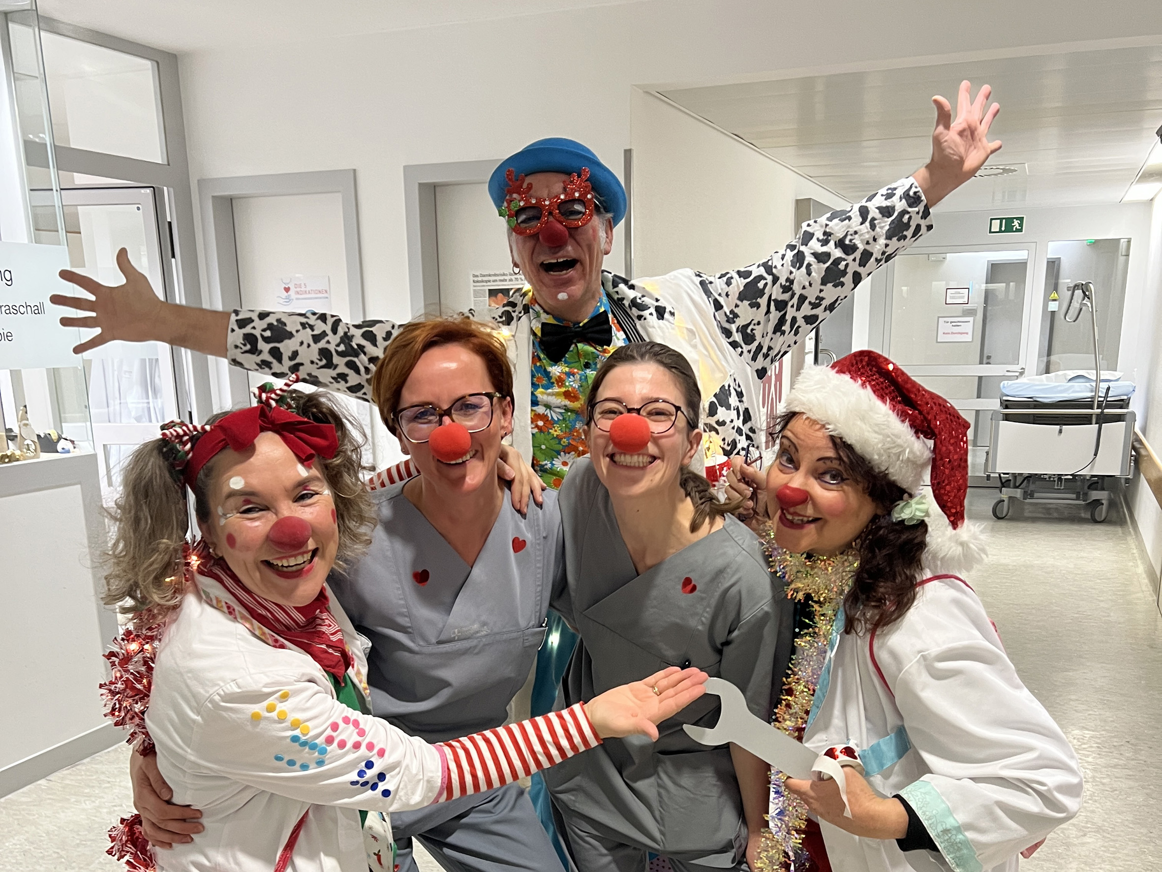 Drei Clowndoktoren und zwei Mitarbeitende der Endoskopie stehen lachend in der Klinik
