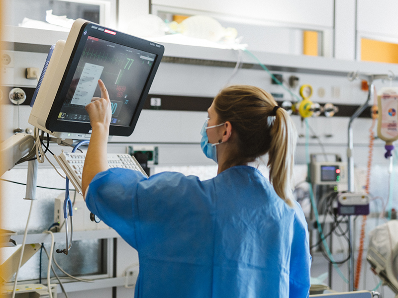 Intensivpflegekraft kontrolliert die Werte eines Patienten am Monitor