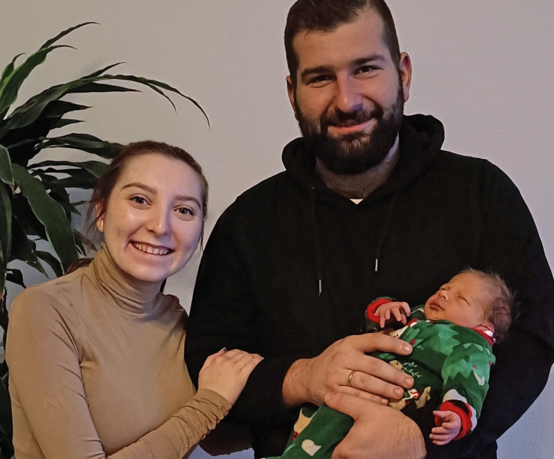 Mutter und Vater halten neugeborenes Baby im Arm