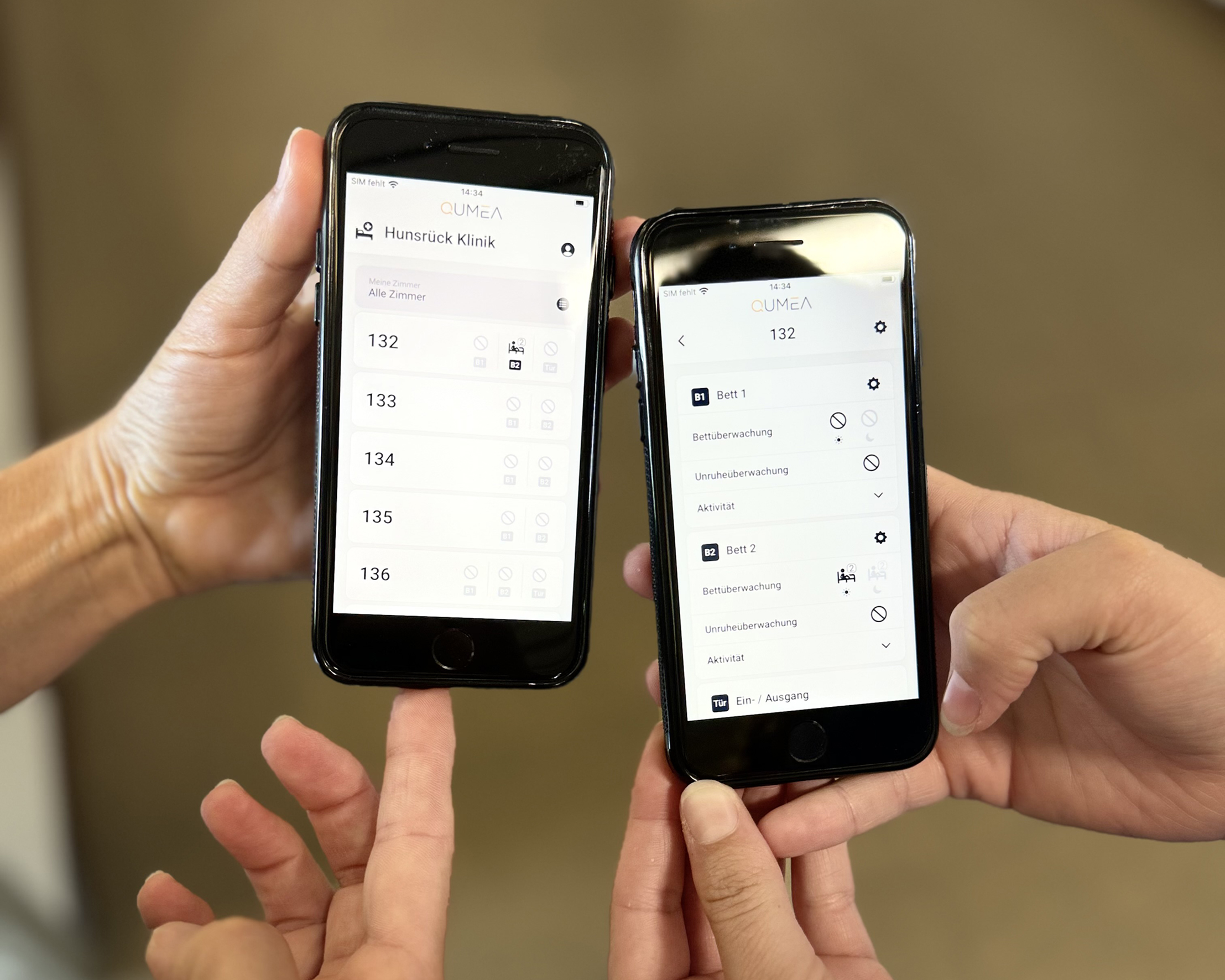 Vier Hände halten Smartphone mit Mobilitäts-Monitoring Ansicht