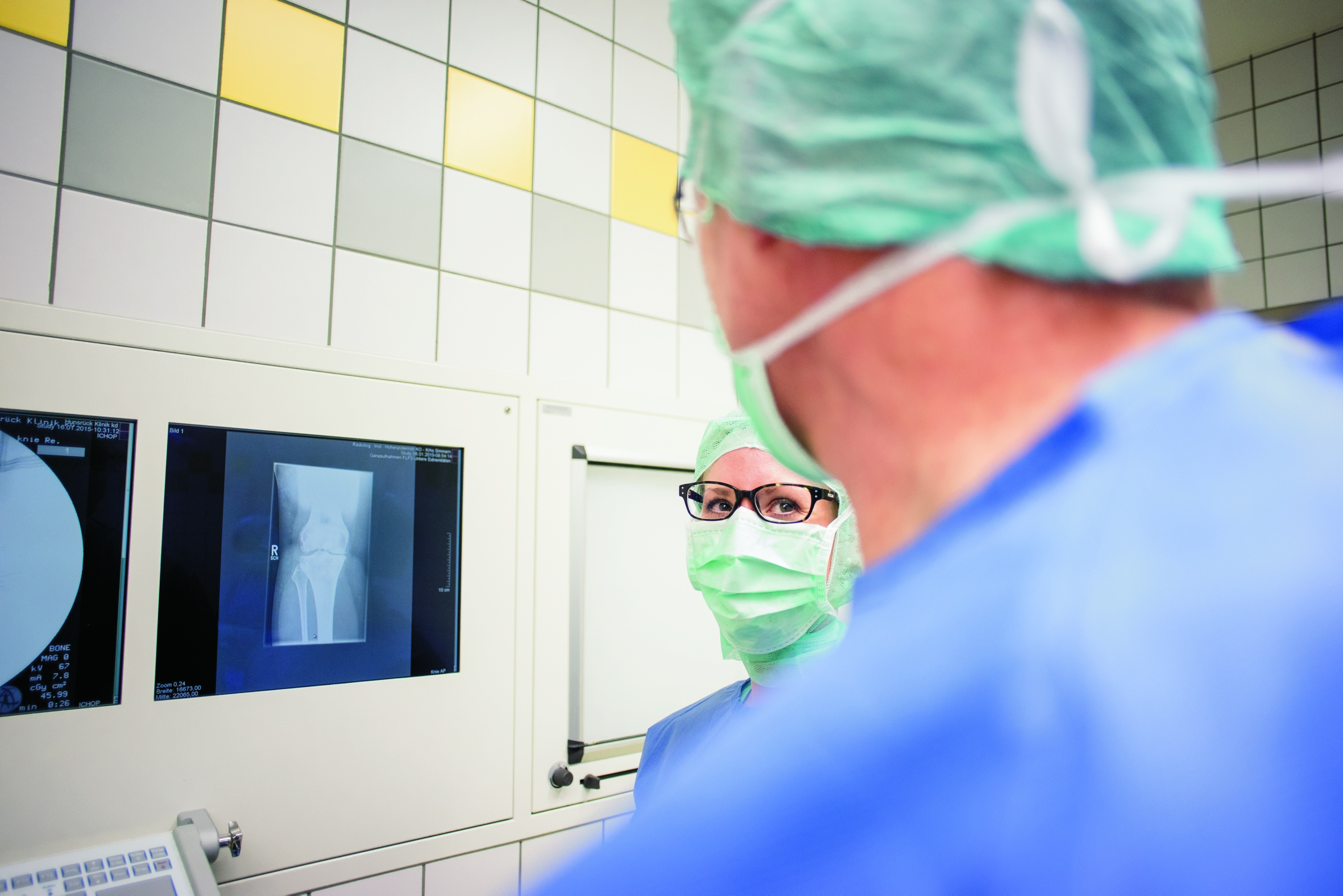 Zwei Chirurgen schauen sich im OP ein Röntgenbild an