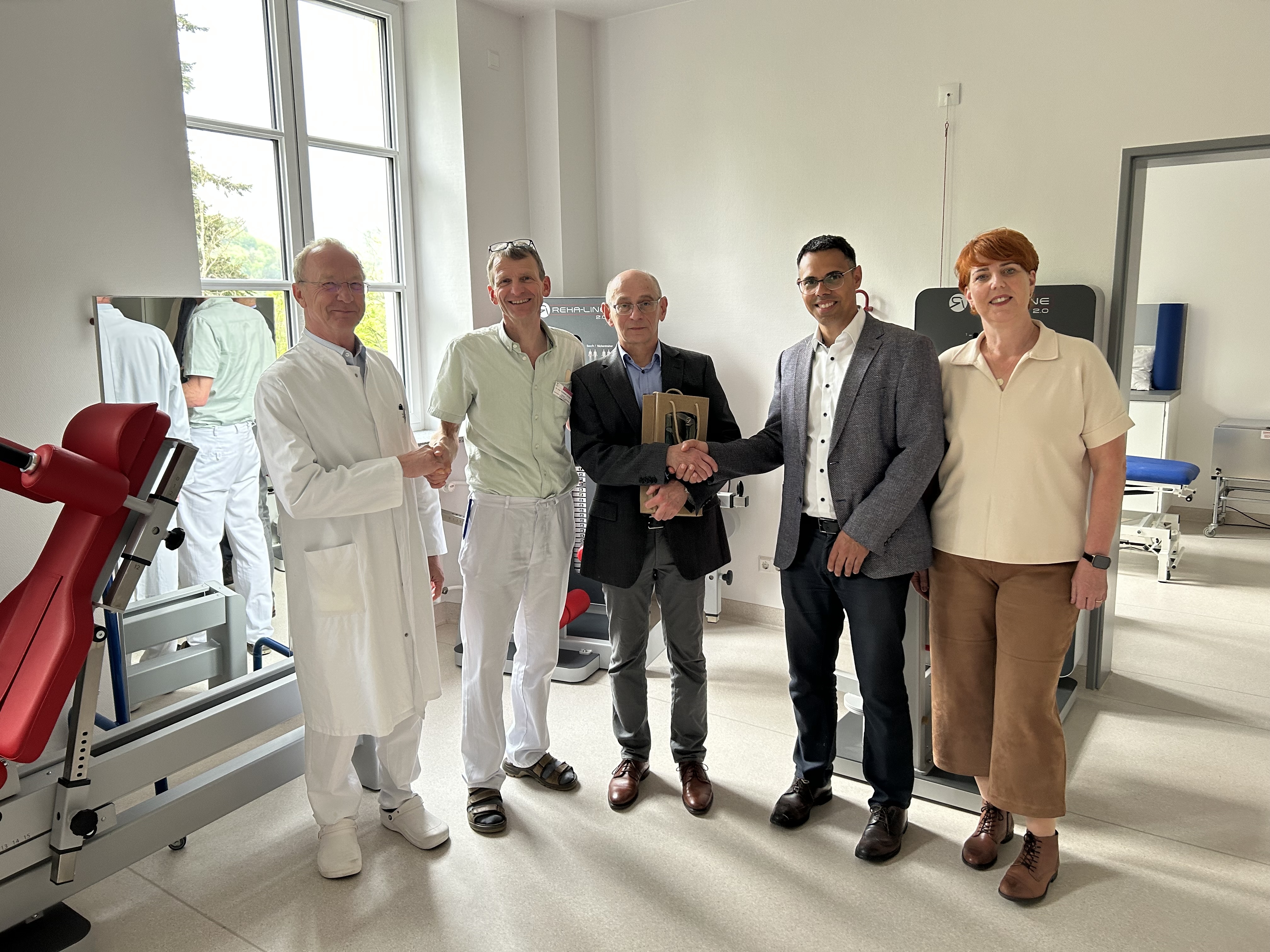 Personen schütteln sich die Hände und gratulieren